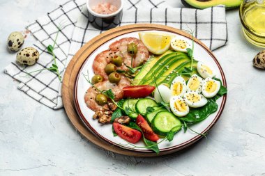 Karides, karides, yağda yumurta, taze salata, domates, salatalık ve avokado. Ketogenik diyet kahvaltısı. Keto, paleo yemeği. Üst görünüm.