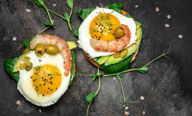 Karides, karides, yağda yumurta, taze salata, domates, salatalık ve avokado. Ketogenik diyet kahvaltısı. Keto, paleo yemeği. Üst görünüm.