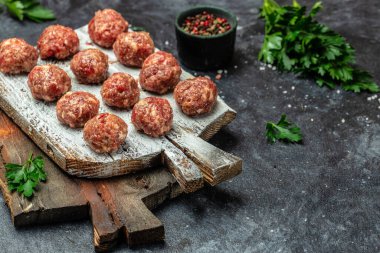 Kesme tahtasında baharatlı taze çiğ et köfteleri koyu arkaplan, pankart, menü, metin için tarif yeri, üst görünüm.