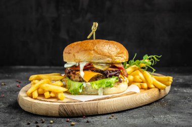 Ev yapımı hamburger, ızgara et, sebze, ahşap arka planda sos. Fast food ve abur cubur kavramı.