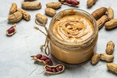 Fıstık ezmeli cam kavanoz ya da arka planda fıstık ezmesi. Uzun afiş biçimi. en üstteki görünüm.