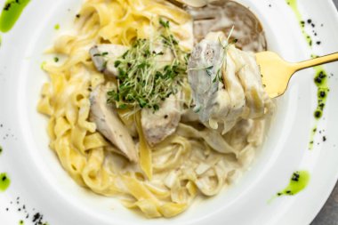 Kremalı soslu, tavuklu Fettuccine Alfredo, beyaz tabakta parmesan. Tavuk soslu makarna. İtalyan mutfağı. afiş, menü, metin için tarif yeri, üst görünüm.