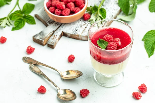 Hafif arka planda ahududu reçelli ahududu panna cotta. Küçük kavanozlarda krema soslu böğürtlen tatlısı. metin için yer.