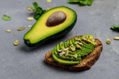 Sağlıklı avokado tostları, çavdar ekmeği ve dilimlenmiş avokado. Vejetaryen vejetaryen menüsü, tarif. Lezzetli kahvaltı ya da atıştırmalık, temiz yemek, diyet, vejetaryen yemek konsepti. en üstteki görünüm,