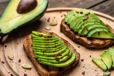 Avokado, çavdar ekmeği, dilimlenmiş avokado. Vejetaryen vejetaryen menüsü, tarif. Lezzetli kahvaltı ya da atıştırmalık, temiz yemek, diyet, vejetaryen yemek konsepti. en üstteki görünüm.
