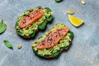 Avokado ezmeli ve somonlu tam tahıllı ekmek. Keto Paleo diyeti. Restoran menüsü, diyet, yemek kitabı tarifi üst görünümü.