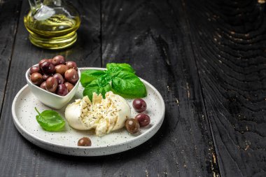 Beyaz tabakta fesleğenli ve zeytinyağlı kremalı İtalyan Burrata peyniri. İtalyan Akdeniz mutfağı. afiş, menü, metin için tarif yeri, üst görünüm.