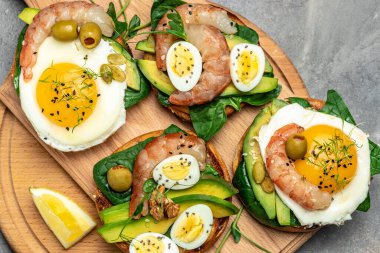 Tost ekmeği, yağda yumurta, ıspanak, avokado, karides ve ketogenik kahvaltı. Süper yiyecek konsepti. Sağlıklı, temiz yemek. Üst görünüm.