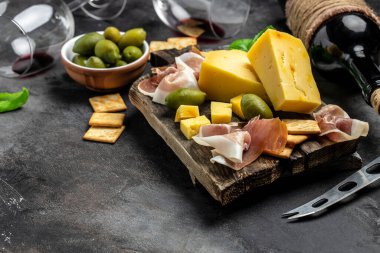 Antipasto tabağı İspanyol jamonu serrano ya da İtalyan prosciutto crudo, koyu arkaplanda İtalyan sert peynirli pecorino toscano. en üstteki görünüm.