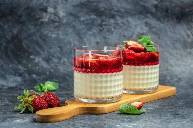 Mavi arka planda çilek soslu panna cotta vanilya. Metin için boşluk.