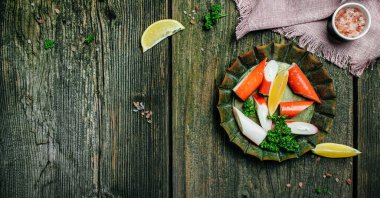 Tahta tahtada taze dilimlenmiş yengeç dilimleri Surimi. Yemeye hazır. Uzun afiş biçimi. en üstteki görünüm.