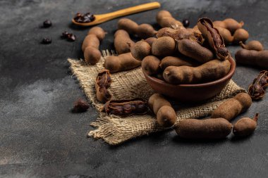 Kahverengi bir kasapta kabuklu fasulyeler koyu bir arka planda, sağlıklı meyveler. afiş, menü, metin için tarif yeri, üst görünüm.