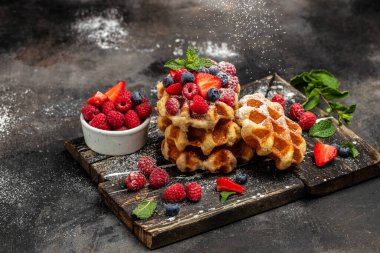 Ahududu, çilek ve yabanmersinli Belçika Waffle 'ı. Mutfak, yemek pişirme, fırın konsepti. Yemek tarifi geçmişi. Kapat..