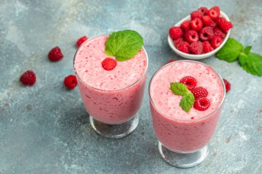 Ahududulu smoothie milkshake ya da böğürtlenli cam kavanozda yoğurt. Mavi arka planda yoğurt kokteyli. metin için yer, üst görünüm.