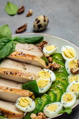 Ketogenik diyet. avokado, ızgara tavuk fileto, bıldırcın yumurtası, ıspanak, ceviz, düşük karbonhidratlı yüksek yağlı kahvaltı, dikey görüntü. Üst Manzara. metin için yer,