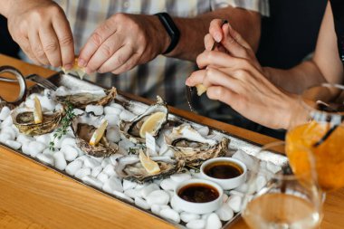 Limonlu taze istiridye. Çiğ açık istiridye, yaşam tarzı yemeği, yemeye hazır. Restoranda şampanyayla istiridye yemeği.