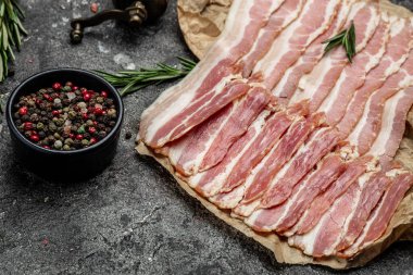 Çiğ domuz pastırması, domuz pastırması ince dilimlenmiş et dilimlenmiş, arka planda domuz yağı, ketojenik diyet, yazı için yer, üst görüş..