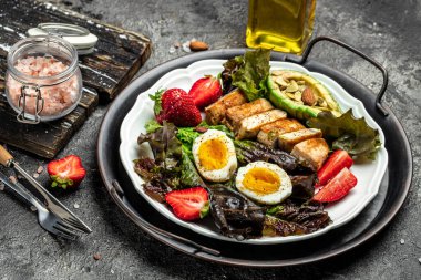 Keto kahvaltısı iki yumurta, avokado, çilek, ızgara tavuk fileto, fındık ve taze salata, ketogenik diyet. Keto diyet yemekli tabak. Sağlıklı gıda konsepti, üst görünüm.