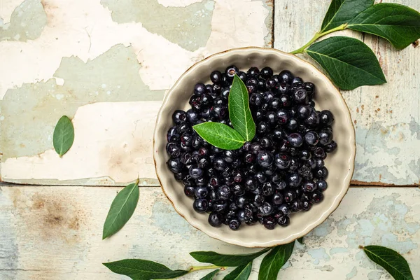 Wild berries, Northern berry: lingonberry, blueberry, Bowl of fresh maqui berry on light background, top view.