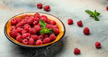 Organik ahududu, kasede taze ahududu. Olgun sulu taze ahududu. Sağlıklı yiyecekler, vitaminler, yaz meyveleri. Uzun afiş biçimi. metin için yer,