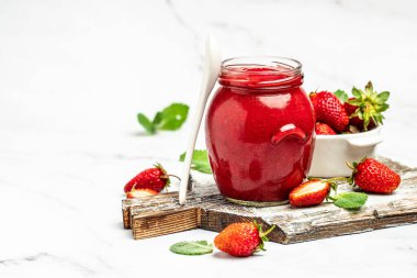 Beyaz arka planda bir kavanoz çilek reçeli. Ev yapımı çilekli marmelat ve meyve. Uzun pankart biçimi.