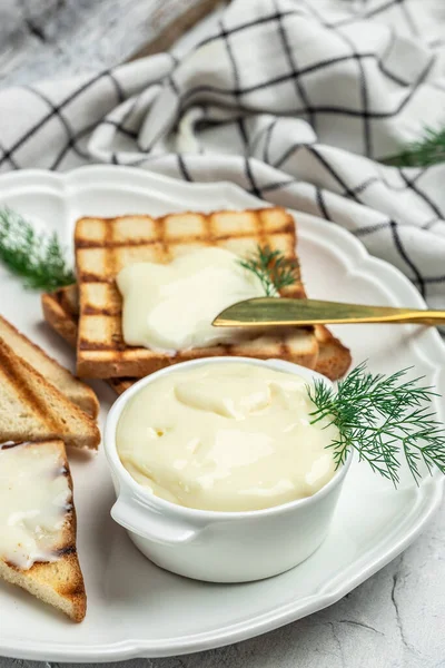 cream cheese and butter for breakfast. melted cheese on light background. vertical image. place for text.