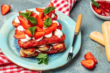 Mascarpone ve naneli çilekli tiramisu. Mavi arka planda çilekli geleneksel İtalyan tatlı tiramisusu. Yemek tarifi geçmişi. Kapat..