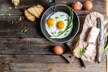 Ukrayna kahvaltısı kızarmış tavada yumurta, domuz yağı, ekmek ve yeşil tüylü soğan. en üstteki görünüm.