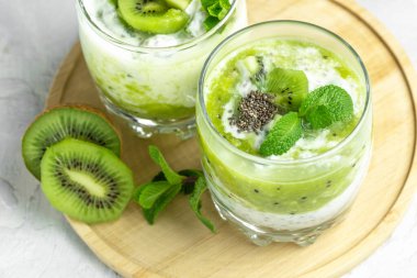 Laktozsuz yoğurt, chia tohumu, kivi ve nane, lezzetli kahvaltı veya aperatif, bayrak, menü, tarif, yazı, temiz yemek, diyet, vegan gıda konsepti. en üstteki görünüm.