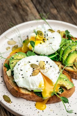 Tahta masada ıspanaklı sandviç, avokado, yumurta ve balkabağı tohumu, sağlıklı yemek, keto diyeti, diyet öğle yemeği konsepti. dikey görüntü. Üst Manzara. metin için yer.