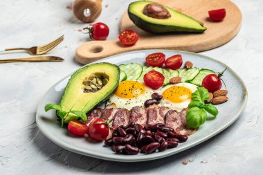 Ketogenik diyet öğün avokado, kızarmış yumurta, pastırma ve fasulye. Sağlıklı besleyici paleo keto kahvaltı diyeti öğle yemeği. Pankart, yemek servisi menü tarifi yeri, metin, üst görünüm.