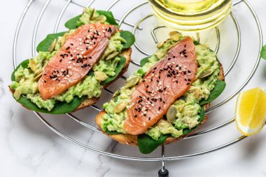 Avokadoo, somon ve ıspanak, fındık ve ayçekirdeği ile tost. Sağlıklı, temiz yemek. Vejetaryen ya da glütensiz diyet. Üst görünüm, boşluk kopyala.