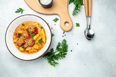 Etli, patatesli, soğanlı güveç, domates soslu kabak, sarımsak ve otlar beyaz bir kasede, yazı için yer, üst görünüm,