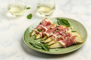 Armut, mavi peynir, jambon ve fesleğenli aperatif. Beyaz şaraplı İtalyan antipasto. afiş, menü, metin için tarif yeri, üst görünüm.