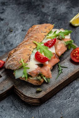 Ev yapımı ciabatta ekmekli sandviçler, tuzlu somon balığı, parmesan peyniri, kapari, vişneli domates ve roka, restoran menüsü, diyet, yemek kitabı tarifi üst görünümü,