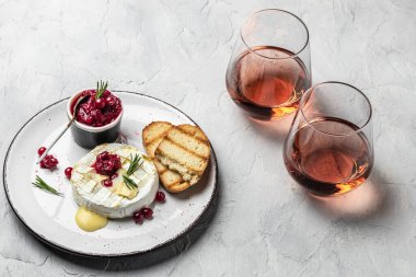 Fransız mutfağı. Kızılcık ve fesleğen yapraklı fırınlanmış camembert peyniri, arka planda hafif bir şarap, afiş, menü, metin için tarif yeri.