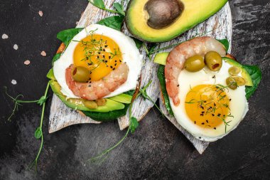 Karides, karides, yağda yumurta, taze salata, domates, salatalık ve avokado. Ketogenik diyet kahvaltısı. Keto, paleo yemeği. Üst görünüm.