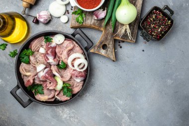 Çiğ tavuk midesi, geleneksel Kore baharatlı tavuk taşlığı soğanlı, sarımsaklı, biberli ve susamlı gri arka planda, yazı için yer, üst görünüm.,