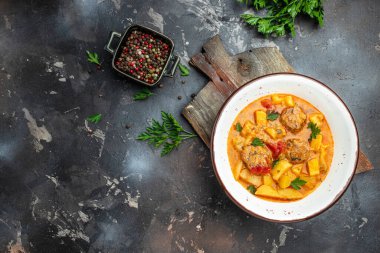 Lecho köftesi, patates, soğan, domates soslu kabak, sarımsak ve otlar beyaz kasede, pankartta, menüde, metnin tarifi, üst görünümde.,