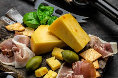 Antipasto tahtasını dilimlenmiş et, jambon, salam, peynir, zeytin ve şarapla kapatın. en üstteki görünüm.