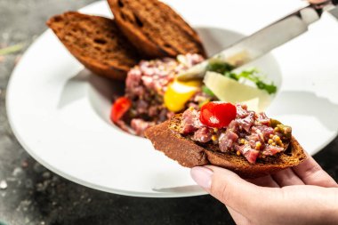 Çiğ bıldırcın yumurtası sarısı, salatalık turşusu ve soğan, taze otlar, ekmek. Fransız mutfağı, afiş, menü, metin için tarif yeri, üst görünüm.