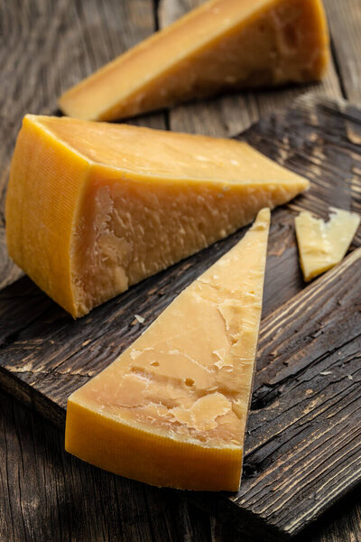 Parmesan cheese on a wooden background. Traditional Italian cheese. place for text, top view.