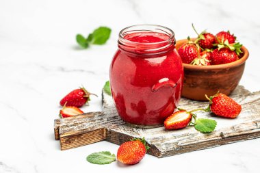 Kavanozda çilek reçeli ve tahtada taze böğürtlen. afiş, menü, metin için tarif yeri.