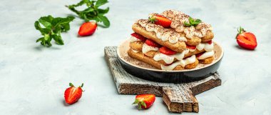 Mascarpone ve naneli çilekli tiramisu. Hafif arka planda çilekli geleneksel İtalyan tatlı tiramisusu. Uzun pankart biçimi.