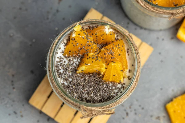 Chia Seed with lactose-free yogurt in glass decorated with citrus fruit. Yogurt with chia seeds on gray background. healthy superfood. Healthy food. place for text.