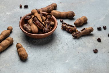 Hafif arka planda sepetin üzerinde leziz olgun tamarindler, uzun afiş formatında. en üstteki görünüm.