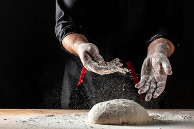 Güzel ve güçlü adamların elleri hamur yoğurur ekmek, makarna ya da pizza yapar. Tozlu un havaya karışıyor. Un bulutunun dondurucu hareketinde un taşıyan şefin elleri.