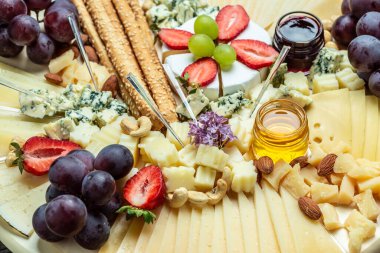 Antipasto peyniri çeşitli yumuşak ve sert peynirlerden oluşan bir pano. İspanyol manchego peyniri, aperatif parti konsepti. Yemek tarifi geçmişi. Kapat.,