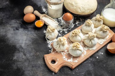 Khinkali. Çiğ khinkali ile tahta kesmek et, yarı bitmiş ürünler hamur köftesi. Khinkali pişirmek. Ulusal Gürcistan mutfağı.