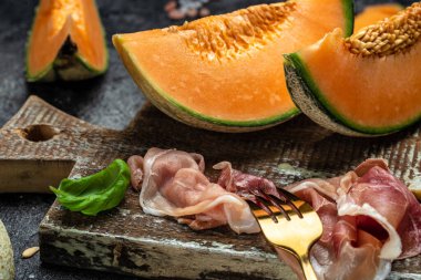 Cantaloupe melon with ham prosciutto jamon. Spanish and Italian snack antipasti appetizer. banner, menu, recipe.